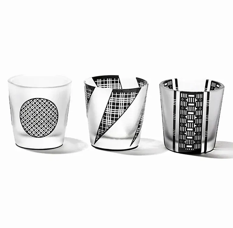 Three black and clear Edo komon engraved cups with different patterns on a white ground