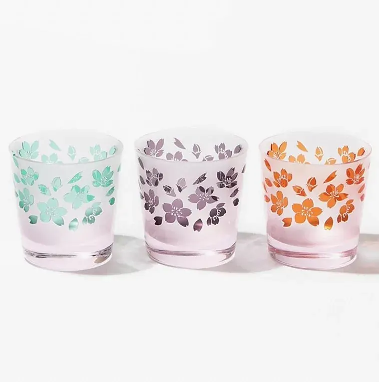 Three frosted pink cups with carved cherry blossoms in green, violet and orange
