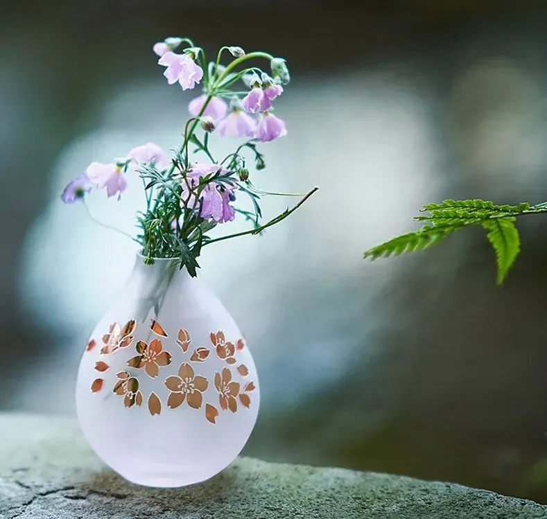 Small frosted vase with an orange blossom pattern holding wildflowers